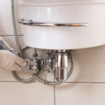 Closeup man fixing sink in a bathroom.