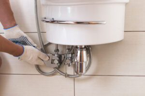 Closeup man fixing sink in a bathroom.